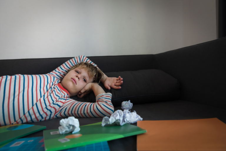 Child lying on the couch after school with signs of executive functioning overload.