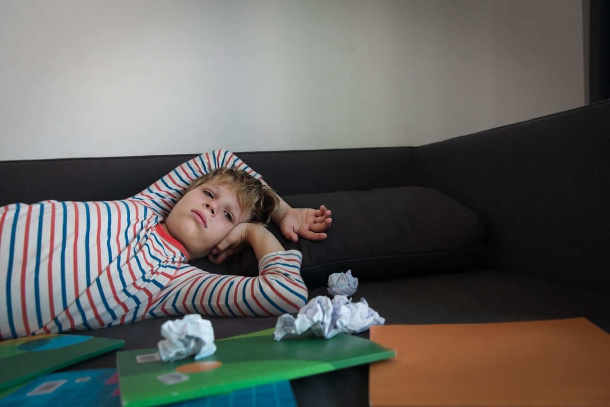 Child lying on the couch after school with signs of executive functioning overload.