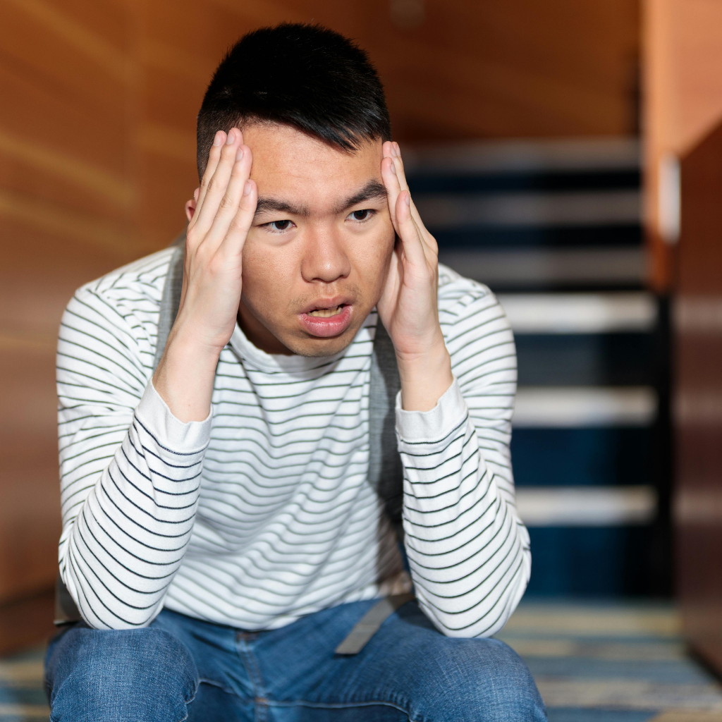 Man showing physical tension and distress from somatic anxiety symptoms.