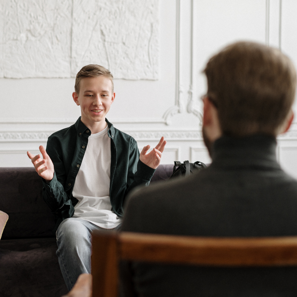 What Is Revenge Sleep Procrastination? Why You Stay Up Even When You're Exhausted 2 Man speaking with a mental health professional about what is revenge sleep procrastination.