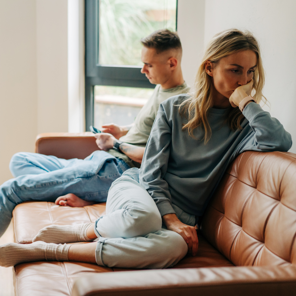 Relationship OCD (ROCD): Symptoms, Patterns, and Treatment 1 Couple sitting apart with emotional distance, reflecting relationship OCD (ROCD) doubt and disconnection.