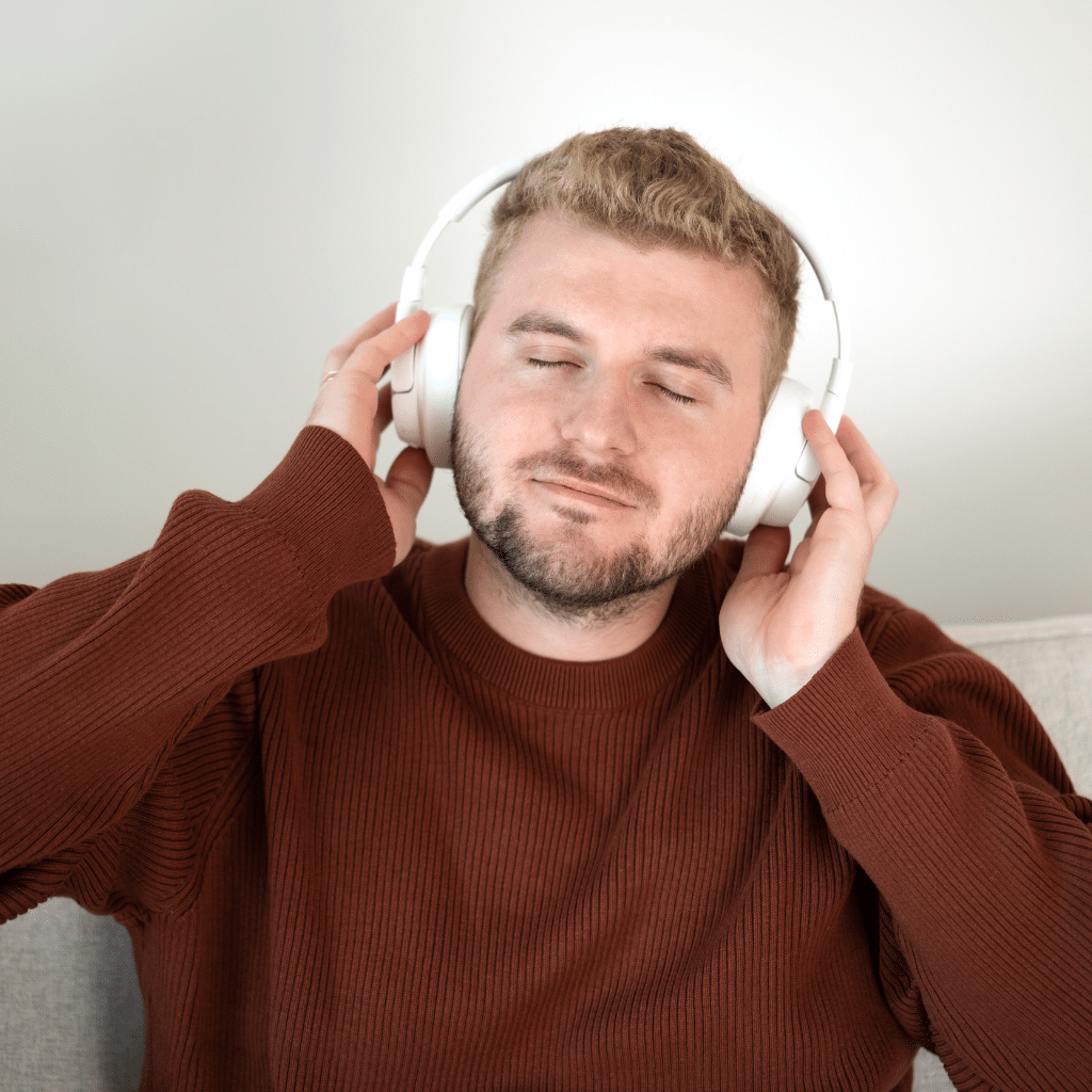 Man using noise cancellation headphones to manage sensory overload.