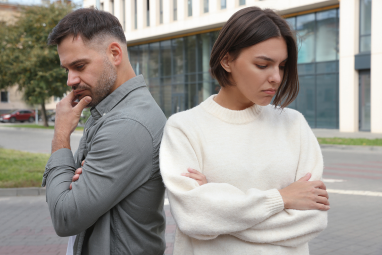 Couple standing apart with visible tension and doubt, representing relationship OCD (ROCD).