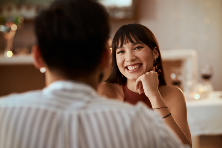 Woman smiling during a dinner date after TMS treatment.