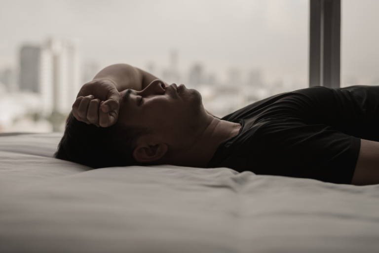 Man lying awake, showing the connection between sleep and mental health.