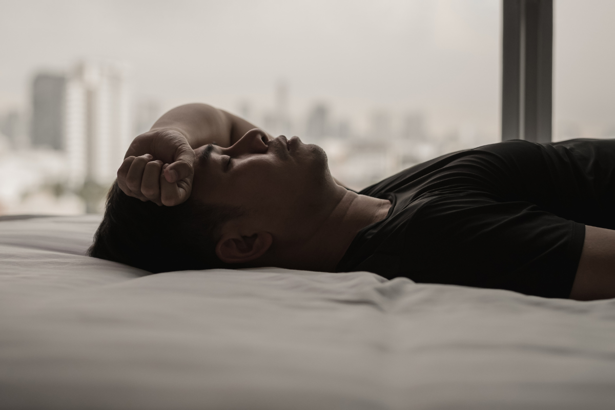 Man lying awake, showing the connection between sleep and mental health.