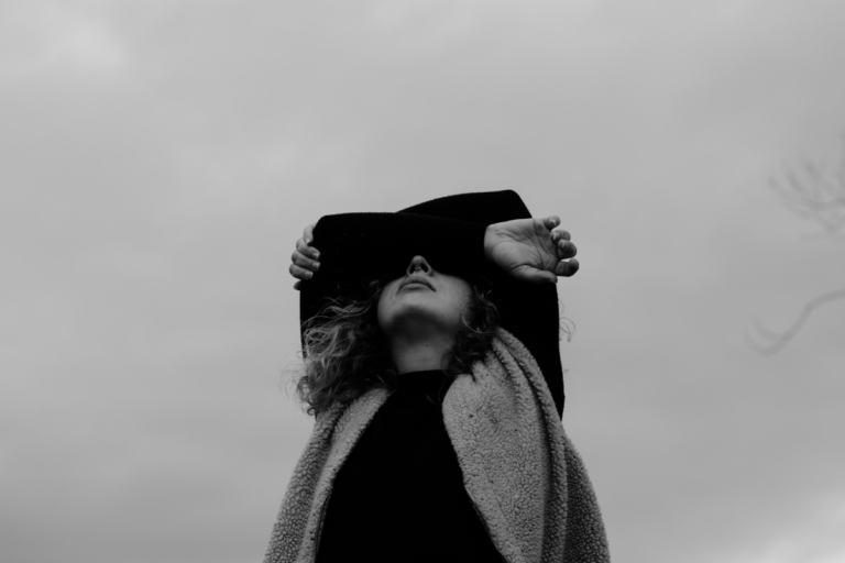 Person covering their face while feeling overwhelmed.