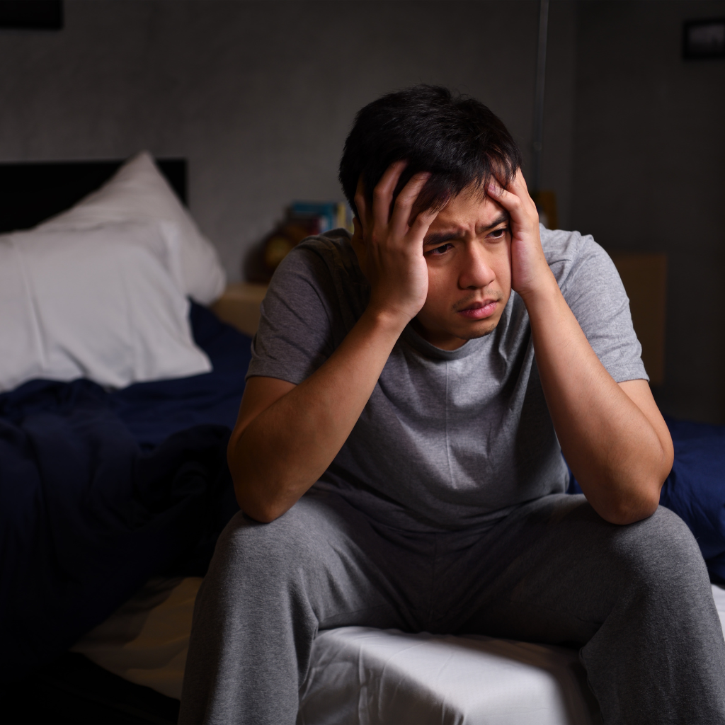 Man awake at night struggling with sleep maintenance insomnia