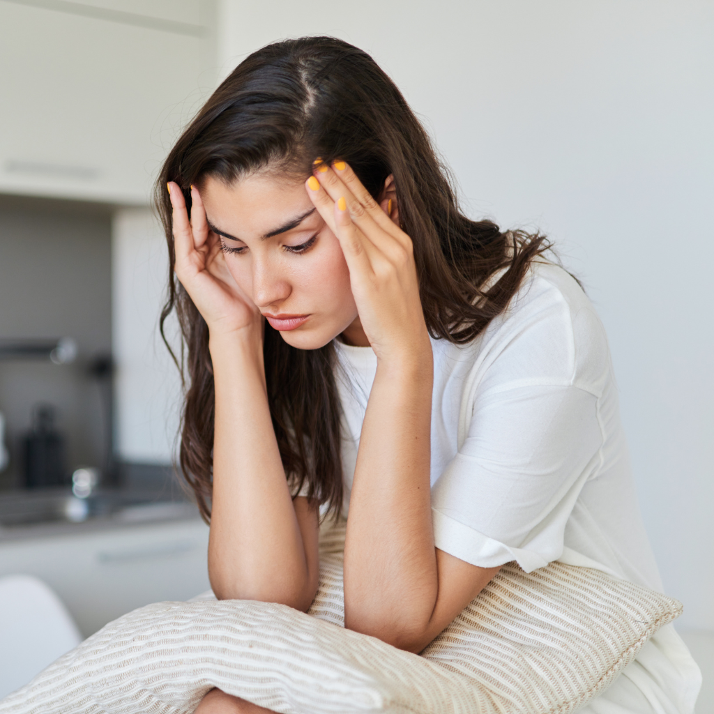 Woman feeling exhausted from poor sleep and mental health struggles.