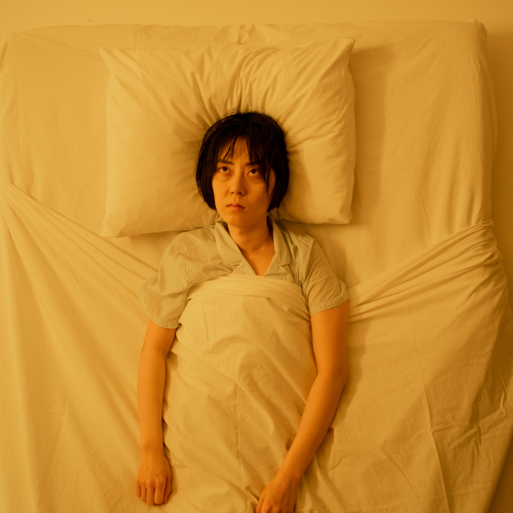 Person lying awake after spending too much time in bed.