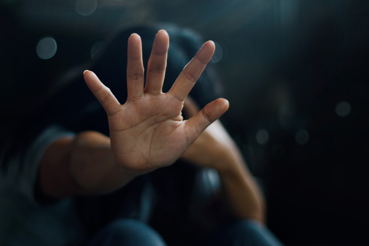 Individual shielding themselves while experiencing anxiety and PTSD-related distress.
