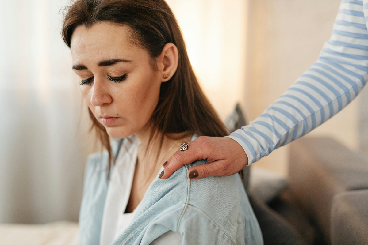 Woman experiencing anxiety while a loved one offers comfort, illustrating reassurance-seeking compulsion in OCD.