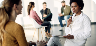 black female doctor communicating with woman group psychotherapy meeting 1