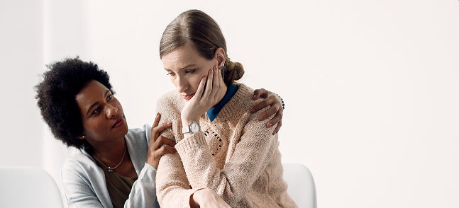 caring african american woman consoling sad woman before group therapy meeting 2 e1781108200363