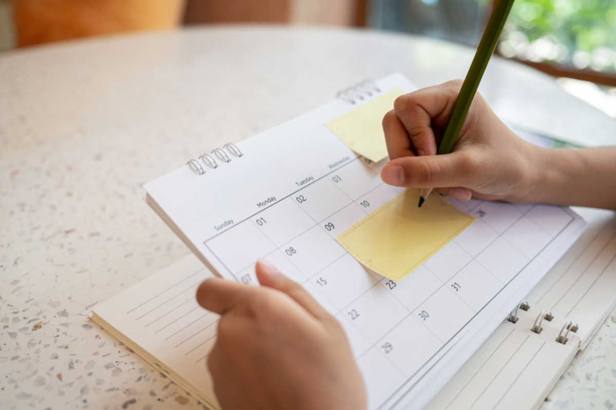 Parent writing notes on a calendar while waiting for a child psychiatric evaluation.