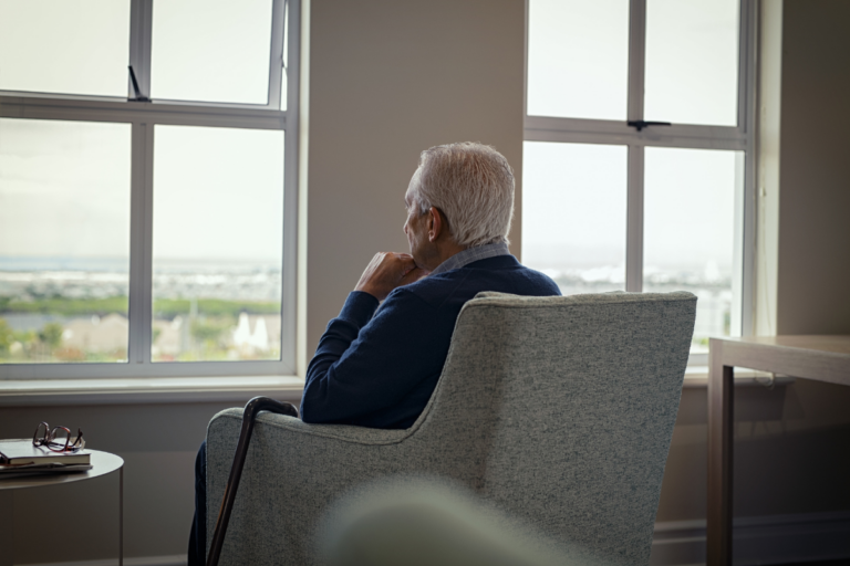Animo Sano Psychiatry 42 Older man sitting alone by a window, reflecting loneliness and isolation in older adults.