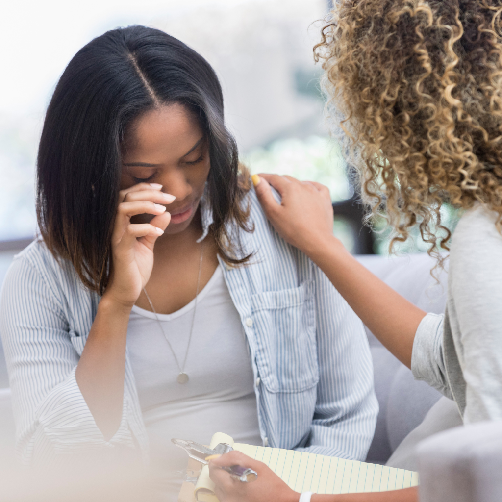 New mother crying during a counseling session, receiving support for postpartum anxiety symptoms.