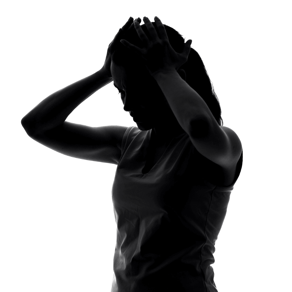 Woman holding her head in silhouette, reflecting severe mood changes that can distinguish PMDD from PMS.