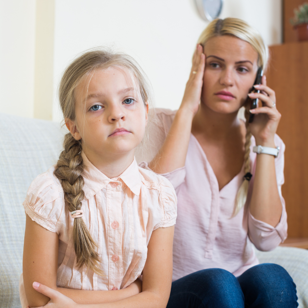 What to Do While You Wait for a Child Psychiatric Evaluation 2 Parent calling for help while sitting beside a withdrawn child, showing when families should not wait for care.