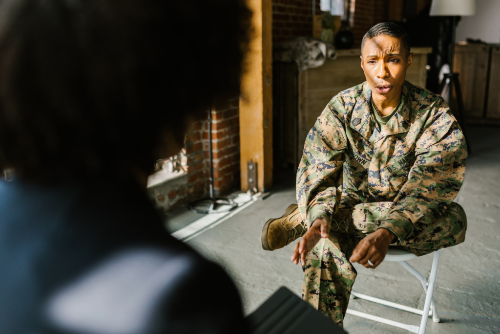 Veteran in uniform speaking with a provider, reflecting support for veterans with PTSD and hypervigilance.