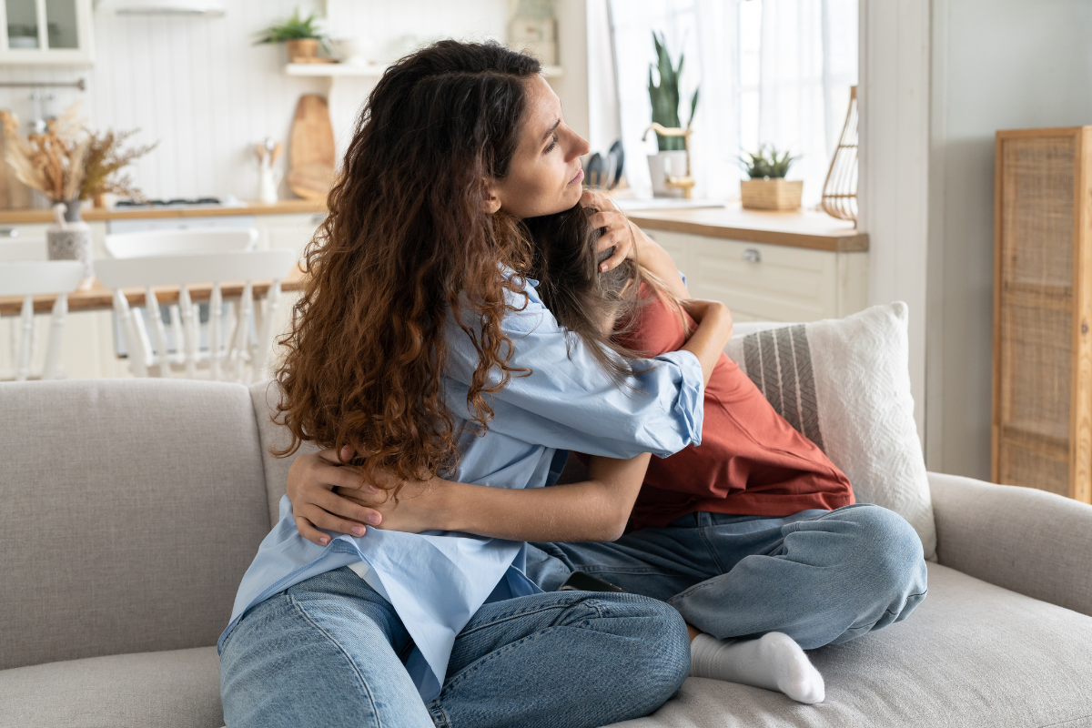Parent hugging a child on the couch, showing the balance between comfort and accommodating child anxiety at home.