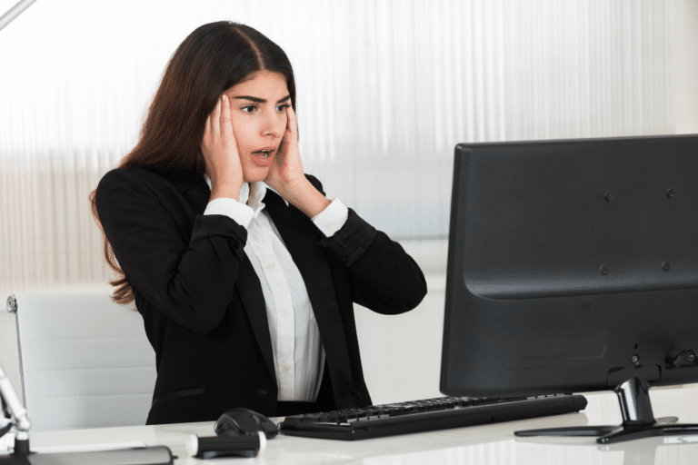 Woman reacting anxiously at her work computer, reflecting how rejection sensitive dysphoria at work can make feedback feel overwhelming.