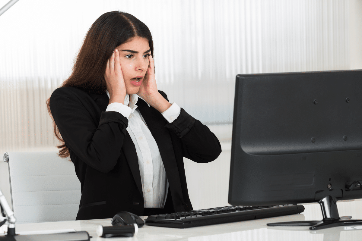 Woman reacting anxiously at her work computer, reflecting how rejection sensitive dysphoria at work can make feedback feel overwhelming.