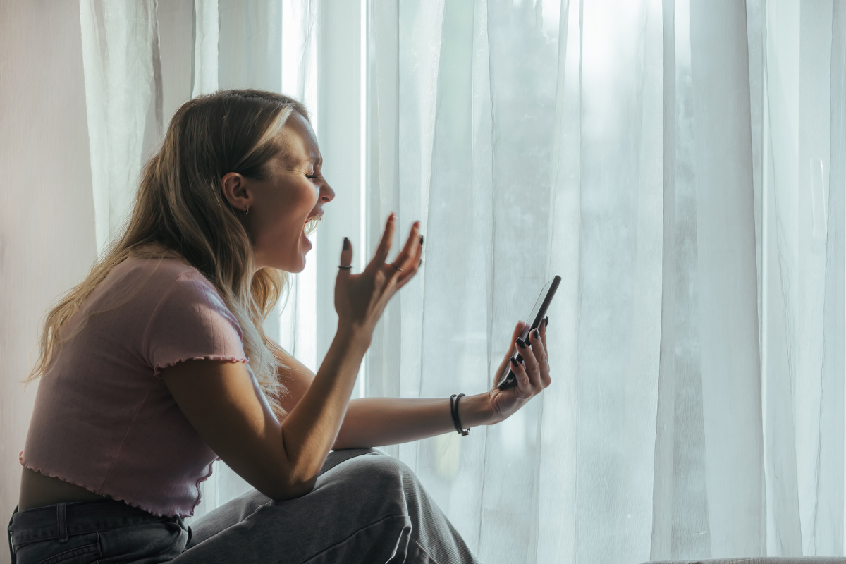 Woman reacting intensely to a phone message, illustrating how emotional dysregulation in BPD can feel sudden and overwhelming.