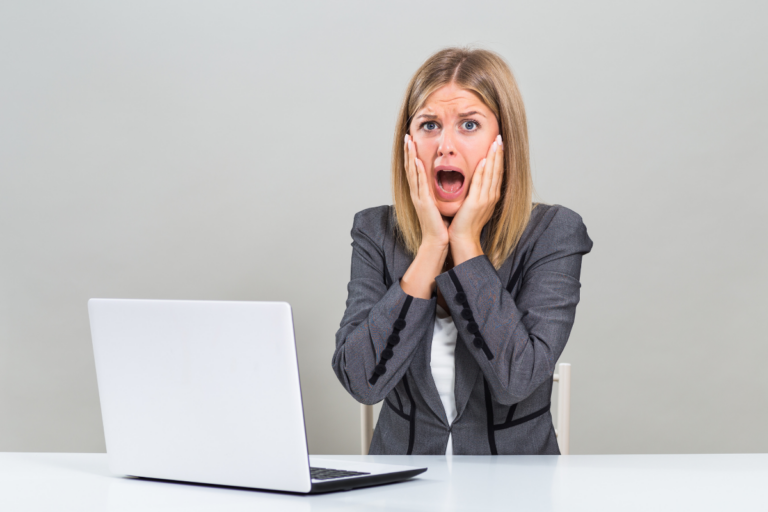 Woman reacting anxiously at a laptop, showing how catastrophizing anxiety can turn everyday situations into worst-case fears.