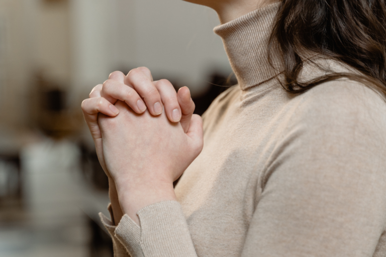 Person with clasped hands in prayer, reflecting how scrupulosity OCD can turn religious fear into repeated doubt.