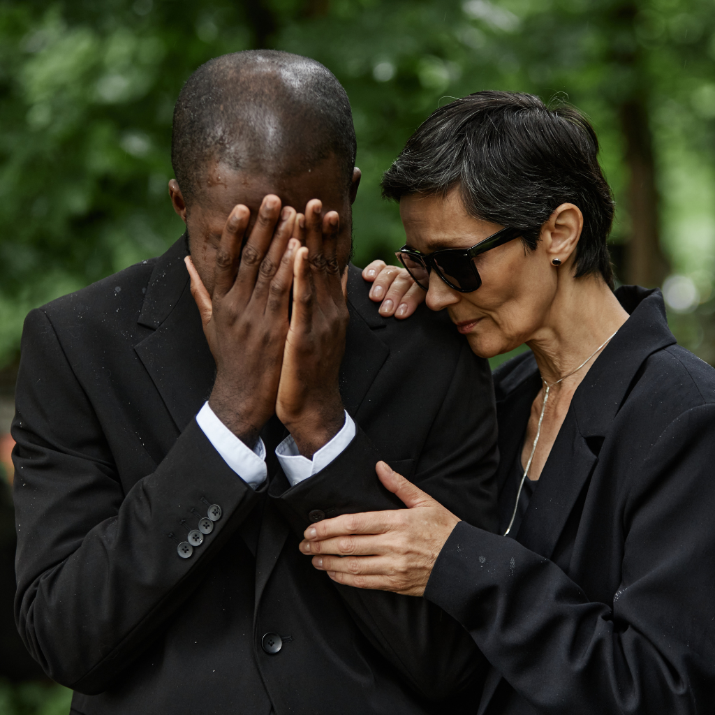 Man grieving after a loss while another person offers comfort, showing grief as a natural response rather than a disorder.