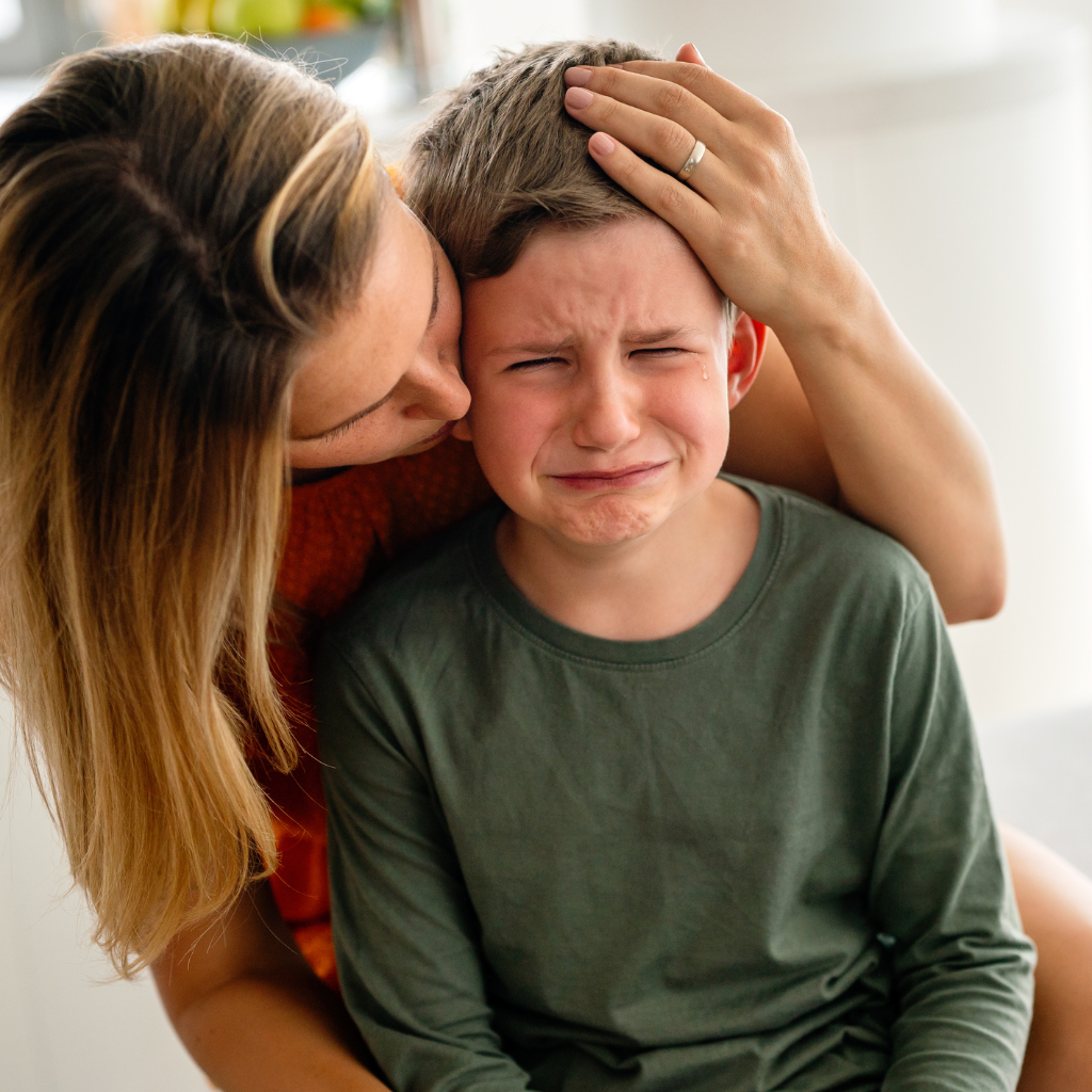 Parent comforting a crying child at home, reflecting how accommodating child anxiety can start with protective instincts.