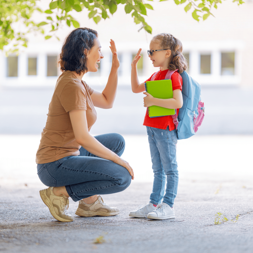 Child high-fiving a parent before school, showing how support can help anxiety in young children feel more manageable.