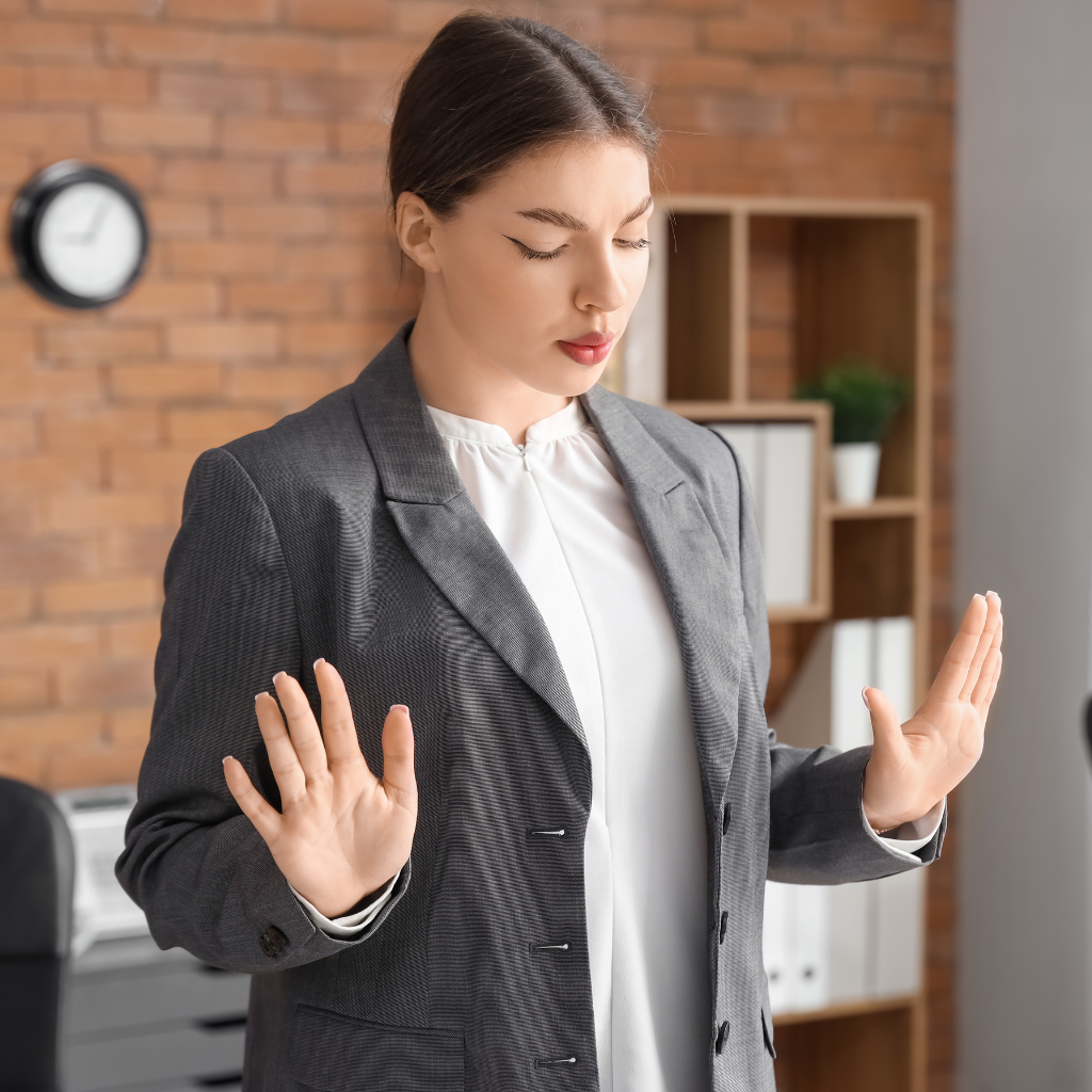 Woman pausing with her hands raised, showing how DBT skills can help manage emotional dysregulation in BPD before reacting.
