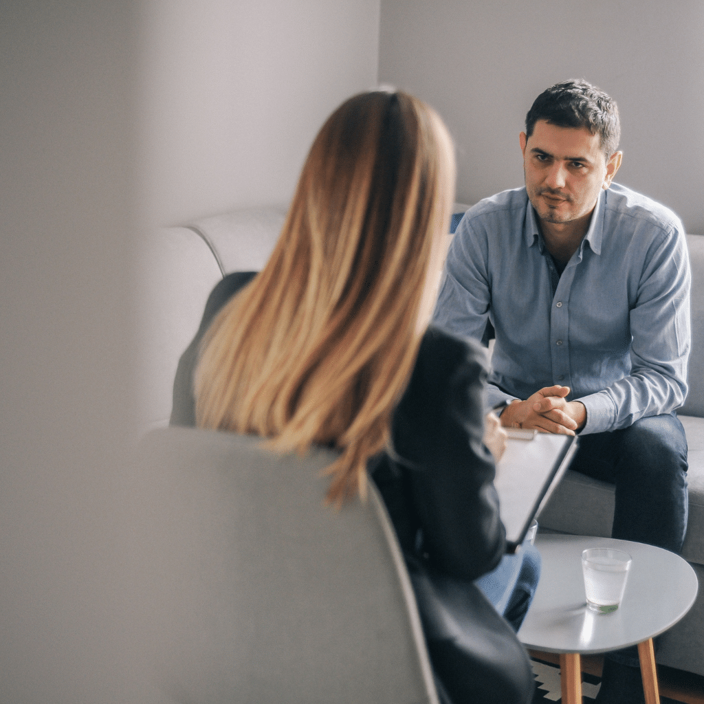 Man speaking with a therapist during a counseling session, showing how asking for help can be a practical first step in mental health care.