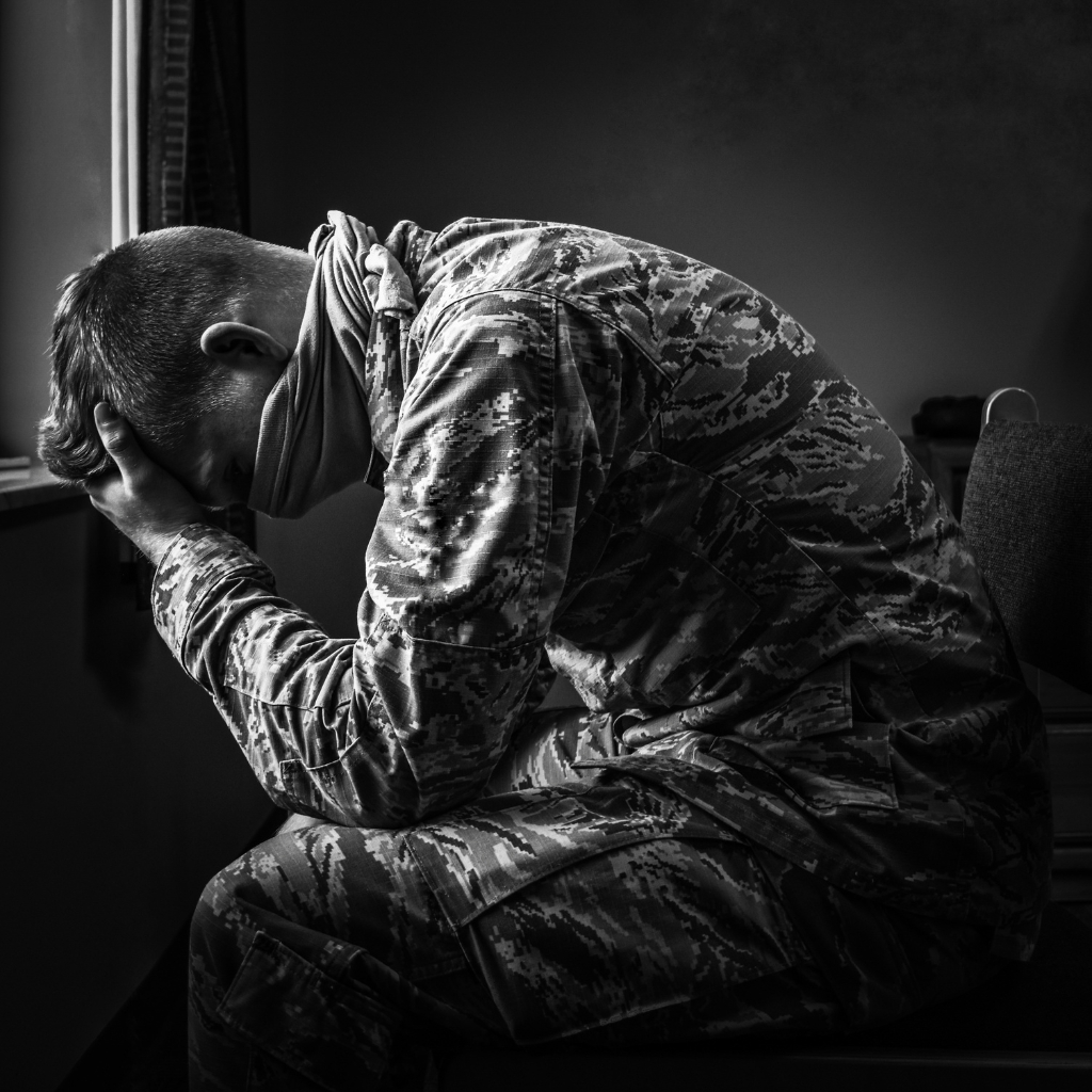 Moral Injury in Veterans: When It's Not Fear, It's Guilt 1 Veteran in uniform sitting with his head in his hands, reflecting the guilt, shame, and emotional weight associated with moral injury.