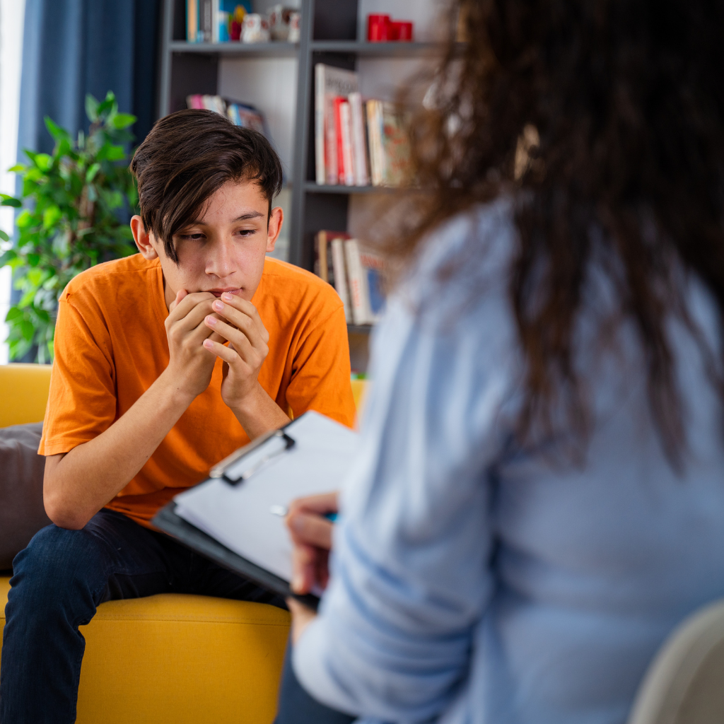 Teen speaking with a therapist during a counseling session about stress and school-related pressure.