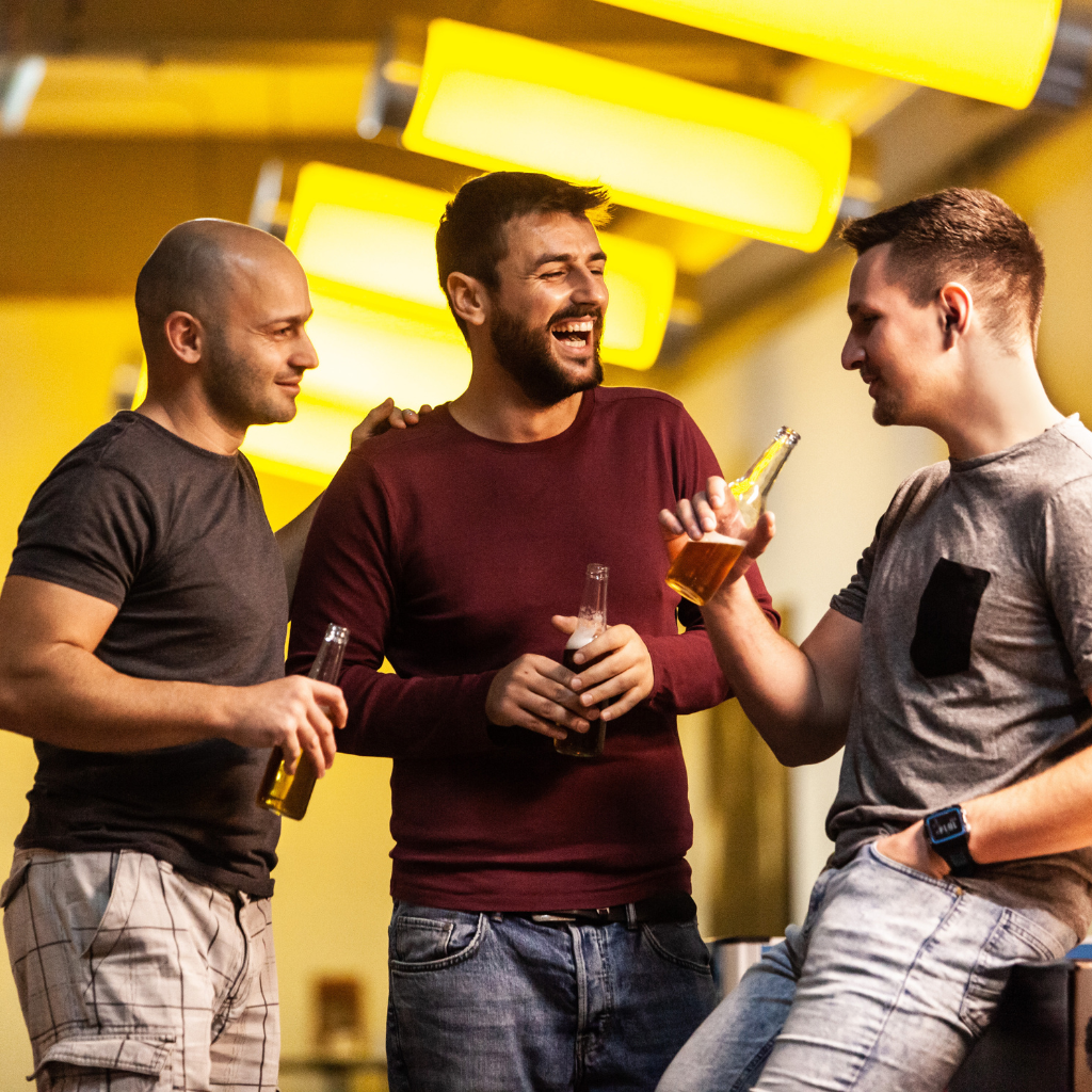 Three men drinking together after work, reflecting how alcohol can become normalized as a way to unwind and bond.