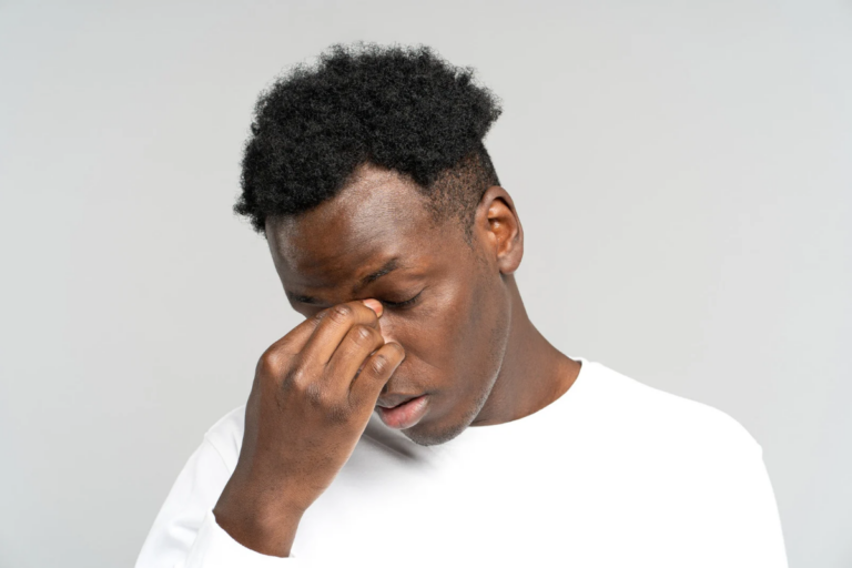 Man rubbing his eyes and looking emotionally drained, reflecting how therapy can leave someone feeling overwhelmed or exhausted after a difficult session.