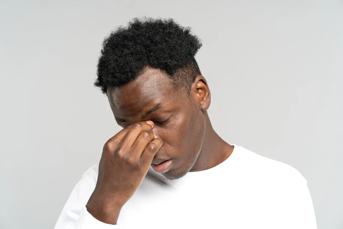 Man rubbing his eyes and looking emotionally drained, reflecting how therapy can leave someone feeling overwhelmed or exhausted after a difficult session.