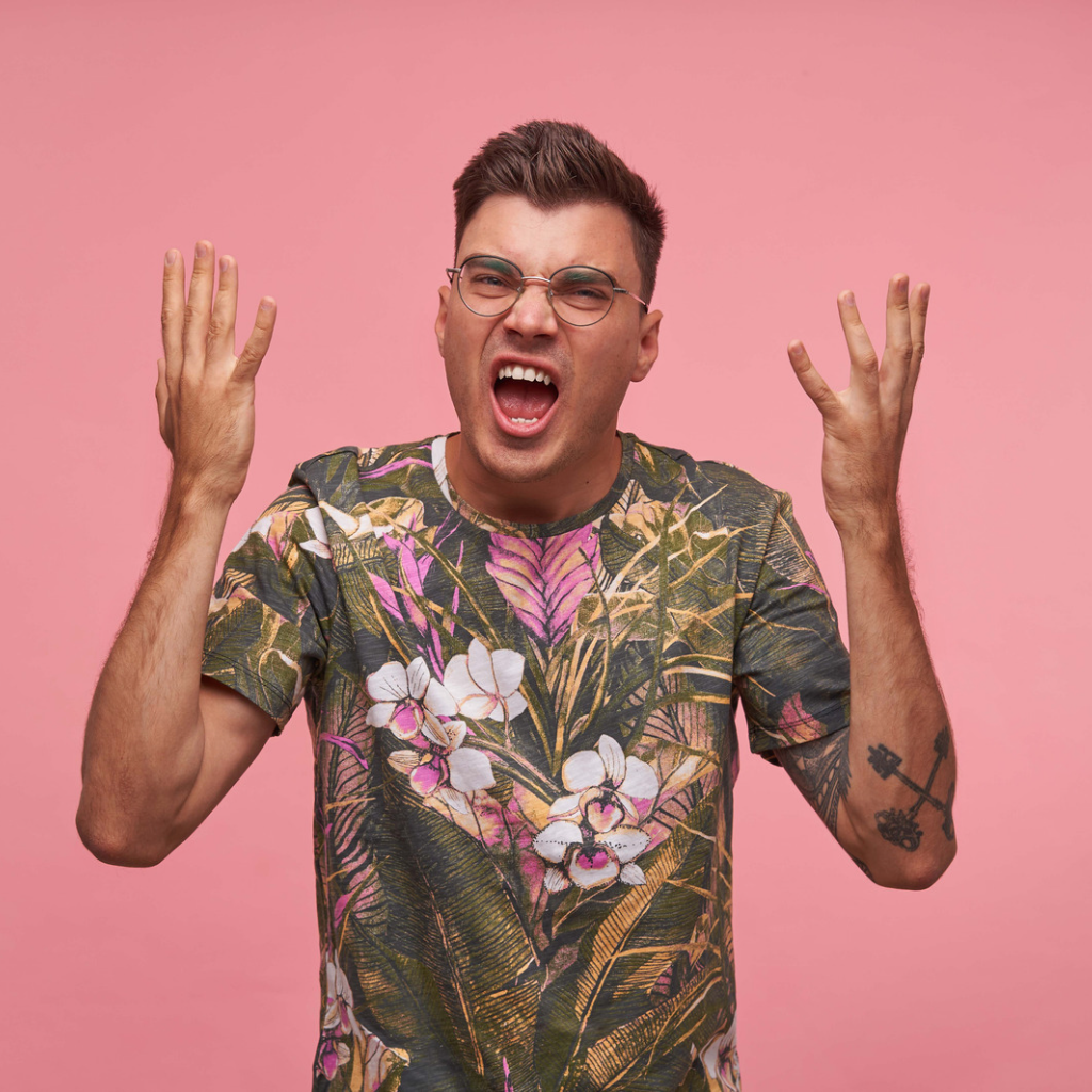 CPTSD Anger and Rage: Why Small Things Set You Off 1 Man shouting with his hands raised in frustration, reflecting a sudden and intense anger response.